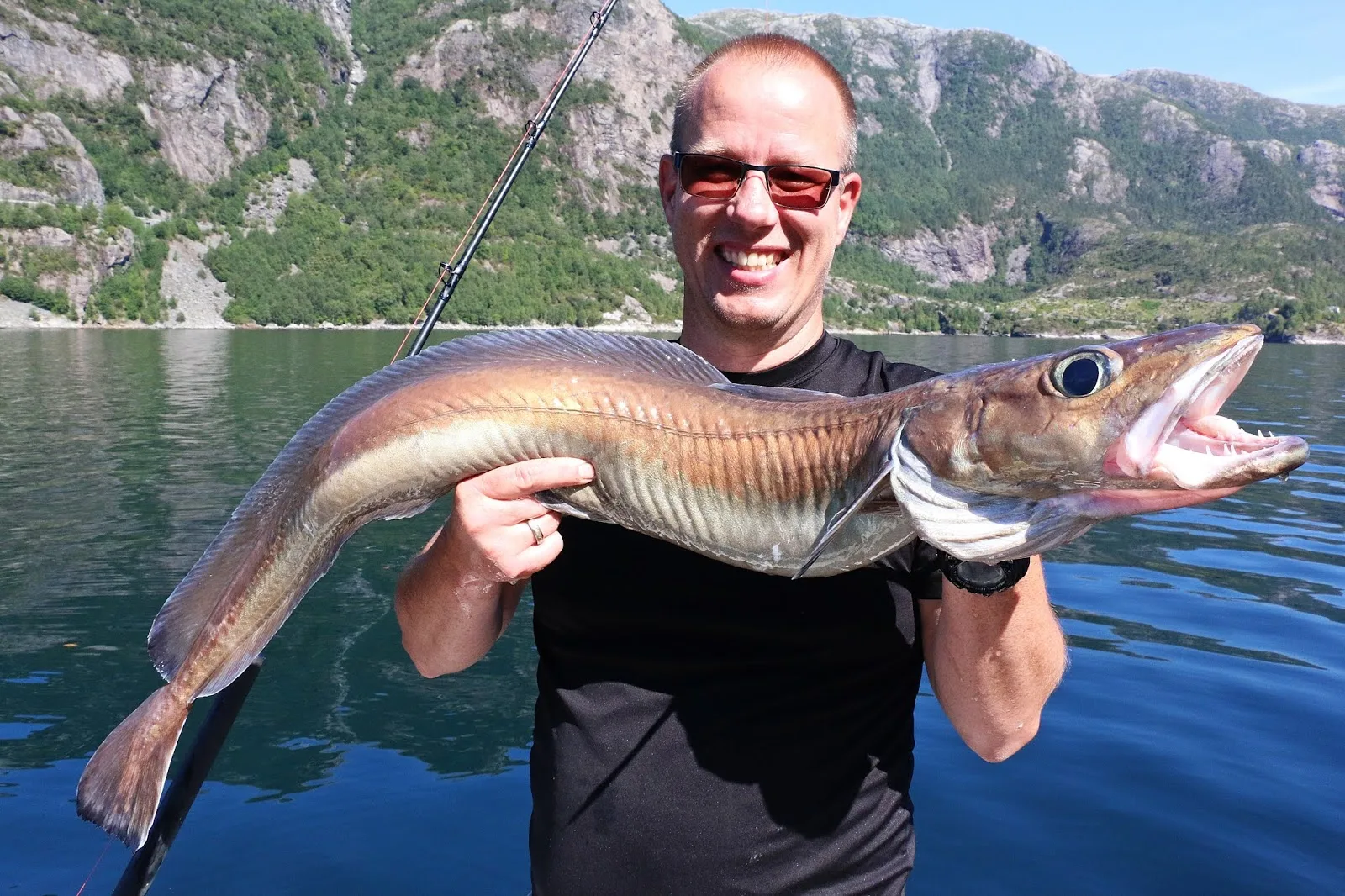 Cato med blålange foran fjord og fjell